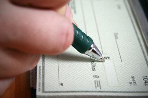 Person signing check in checkbook