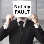 Man Hiding Behind Not My Fault Sign
