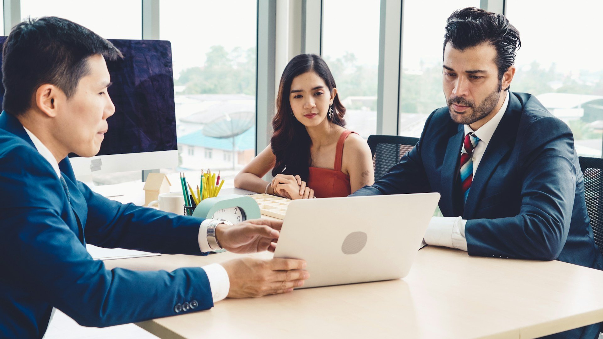 3 office workers looking at laptop