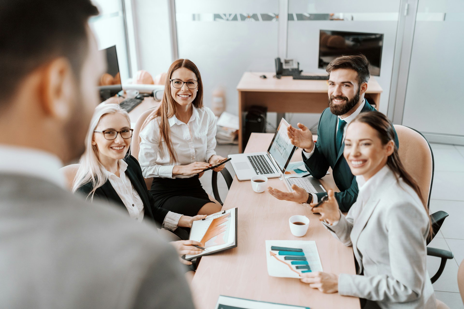 boss looking at team members in board room